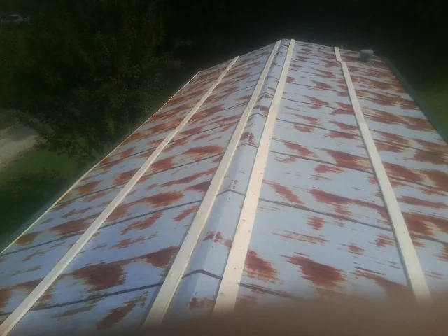 Rusted metal roof panels with new wood purlins before replacement — Storm Damage Roof Repair in Malden by Roofing Brothers