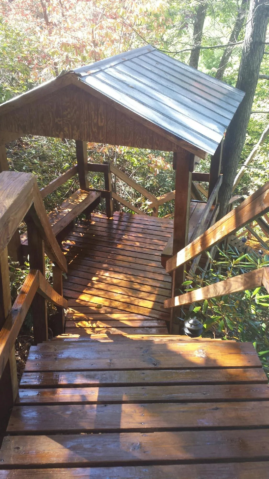 Freshly stained wood walkway and covered shelter with a metal roof in Malden